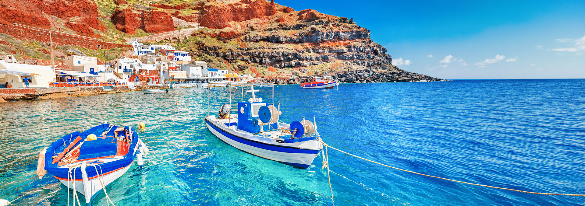 Bateaux au large des côtes de la Grèce dans une mer bleu clair.