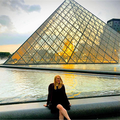 Sarah Ehler assise devant le Louvre