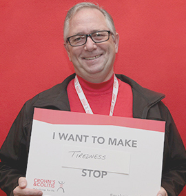 Volunteer holding a "I want to make tiredness stop" sign