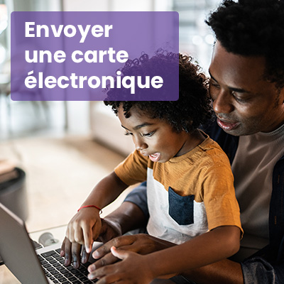 Père noir et son enfant utilisant leur ordinateur (envoyer une carte électronique)