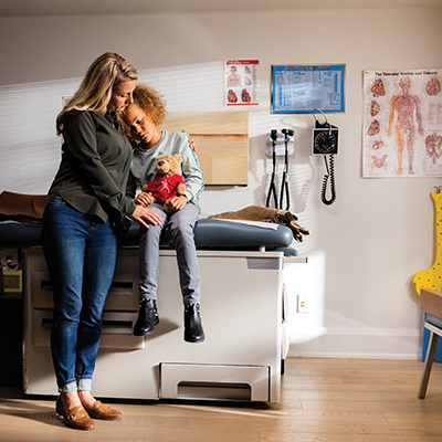 une femme console sa fille dans le cabinet du médecin