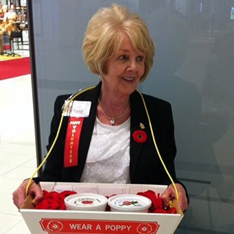 Robbi fait du bénévolat dans un centre d'achat pour vendre des coquelicots pour le jour du Souvenir.